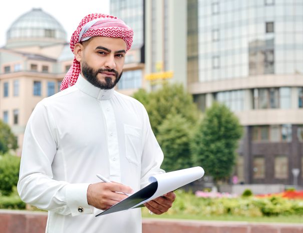 Serious about business. Horizontal shot of a confident Arabic businessman looking to the camera holding a clipboard with documents
